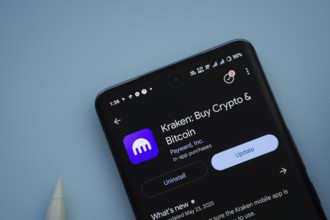 Dhaka, Bangladesh- 29 May 2025: On a blue surface, a smartphone displays the Kraken app within the