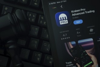 Dhaka, Bangladesh- 28 Oct 2025: An iPad displaying the Kraken Pro app against a judge's gavel and