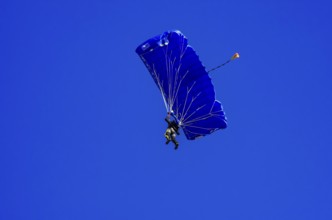 Skydivers during an aerial acrobatic performance as part of an air show at the Fliegerbergfest of
