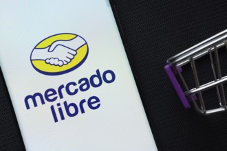 Dhaka, Bangladesh- 03 July 2025: A smartphone displaying the Mercado Libre logo next to a miniature