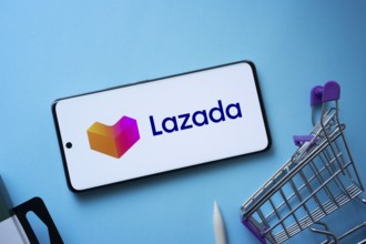 Dhaka, Bangladesh- 03 July 2025: Smartphone displaying Lazada logo with shopping cart on a blue