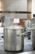 Commercial kitchen pot steaming on a restaurant stove, preparing food for cooking