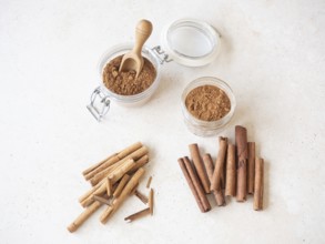 Various cinnamon forms, including ground powder in glass jars and different stick types