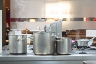 Steaming pots on a commercial stove in a professional kitchen, preparing food