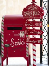 Festive red christmas mailbox and north pole signpost for sending letters to santa claus