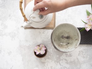 Teapot with bamboo handle and teacup ready for traditional tea ceremony preparation