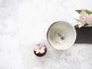 Empty ceramic bowl, pink alstroemeria flowers, and brown placemat creating a minimalist arrangement