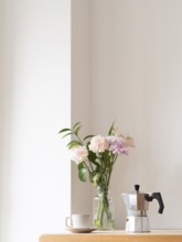 Enjoying a quiet moment with coffee and flowers, creating a cozy and relaxing atmosphere in a