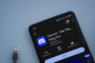 Dhaka, Bangladesh- 03 Oct 2025: On a blue surface, a smartphone displays the Discord app within the