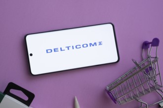 Dhaka, Bangladesh- 03 Oct 2025: Smartphone displaying Delticom logo alongside a shopping cart on a