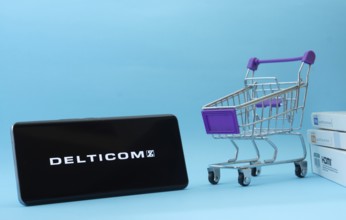 Dhaka, Bangladesh- 03 Oct 2025: Smartphone with Delticom logo next to a small shopping cart and