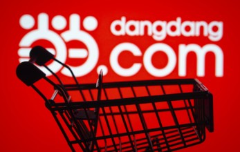 Dhaka, Bangladesh- 03 Oct 2025: Silhouette of a shopping cart in front of the Dangdang.com logo,
