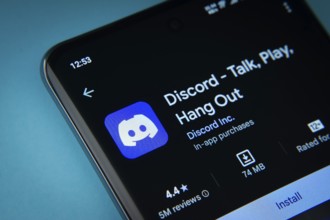 Dhaka, Bangladesh- 03 Oct 2025: On a blue surface, a smartphone displays the Discord app within the