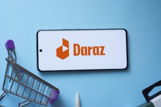 Dhaka, Bangladesh- 03 Oct 2025: Smartphone displaying Daraz logo with shopping cart on a blue