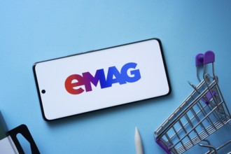 Dhaka, Bangladesh- 03 Oct 2025: Smartphone displaying Emag logo with shopping cart on a blue