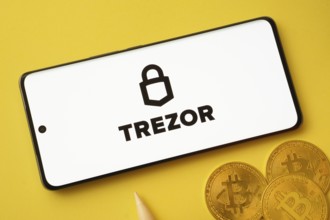 Dhaka, Bangladesh- 30 Sep 2025: Trezor logo on smartphone screen near Bitcoin coin and QR code on