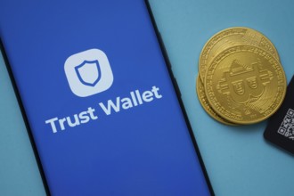 Dhaka, Bangladesh- 30 Sep 2025: Trust Wallet logo on smartphone screen near Bitcoin coin and QR