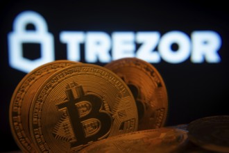 Dhaka, Bangladesh- 20 Sep 2025: Close-up of Bitcoin coins with the Trezor logo visible on a screen
