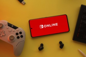 Dhaka, Bangladesh- 15 July 2025: Smartphone with nintendo online logo, game controller, and earbuds