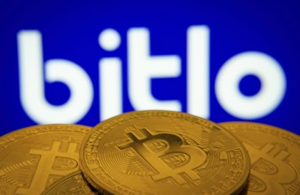 Dhaka, Bangladesh- 03 Sep 2025: Close-up of Bitcoin coins with the Bitlo logo visible on a screen
