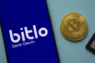 Dhaka, Bangladesh- 03 Sep 2025: Bitlo.com logo on smartphone screen near Bitcoin coin and QR code