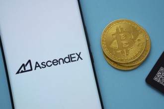 Dhaka, Bangladesh- 02 June 2025: AscendEX logo on smartphone screen near Bitcoin coin and QR code