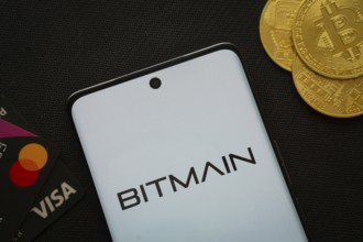 Dhaka, Bangladesh- 15 June 2025: Smartphone displaying Bitmain logo surrounded by Bitcoin coins and