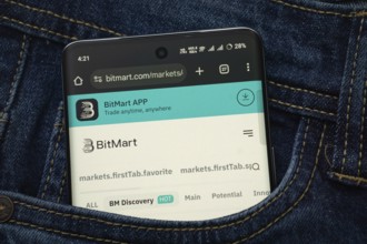 Dhaka, Bangladesh- 15 June 2025: A smartphone displaying the BitMart.com web interface peeks out of