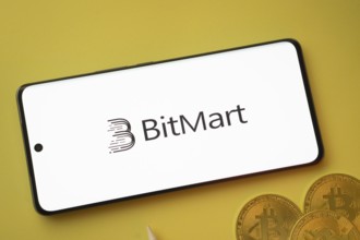 Dhaka, Bangladesh- 15 June 2025: Bitmart logo on smartphone screen near Bitcoin coin and QR code on