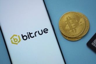 Dhaka, Bangladesh- 03 Sep 2025: Bitrue logo on smartphone screen near Bitcoin coin and QR code on