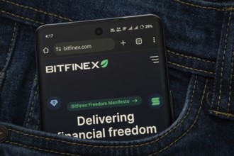 Dhaka, Bangladesh- 15 June 2025: A smartphone displaying the Bitfinex.com web interface peeks out