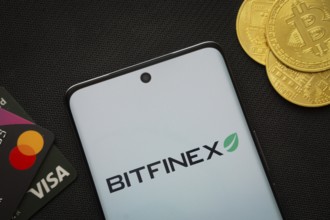 Dhaka, Bangladesh- 15 June 2025: Smartphone displaying Bitfinex logo surrounded by Bitcoin coins
