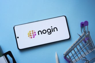 Dhaka, Bangladesh- 03 July 2025: Smartphone displaying nogin logo with shopping cart on a blue