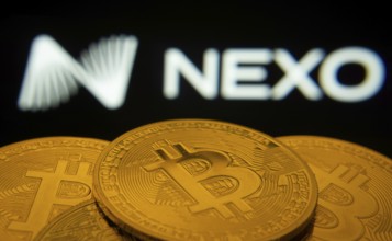 Dhaka, Bangladesh- 06 Sep 2025: Close-up of Bitcoin coins with the Nexo logo visible on a screen in
