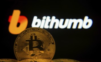 Dhaka, Bangladesh- 07 May 2025: Close-up of Bitcoin coins with the Bithumb logo visible on a screen