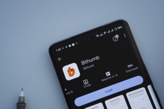 Dhaka, Bangladesh- 07 May 2025: On a blue surface, a smartphone displays the Bithumb app within the