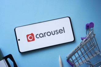 Dhaka, Bangladesh- 03 July 2025: Smartphone displaying Carousell logo with shopping cart on a blue