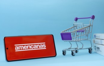 Dhaka, Bangladesh- 03 July 2025: Smartphone with Americanas logo next to a small shopping cart and