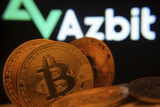 Dhaka, Bangladesh- 02 June 2025: Close-up of Bitcoin coins with the Azbit logo visible on a screen