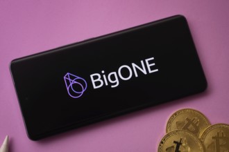 Dhaka, Bangladesh- 15 June 2025: bigONE logo on smartphone screen near Bitcoin coin and QR code on