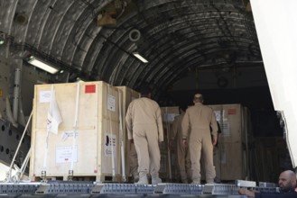 Members of the Qatari Air Force unload humanitarian aid supplies from a transport aircraft at