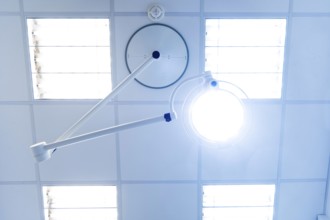 Bright operating or treatment room, view of medical examination light and ceiling lighting from the