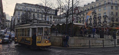 Historic tram on a busy city street surrounded by classic buildings, Lisbon, Portugal