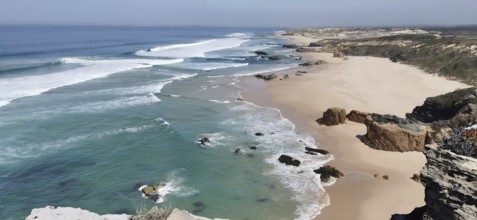 Wide view of sandy beach with waves of sea and cliffs, hiking on the Fisherman's Trail, fishing