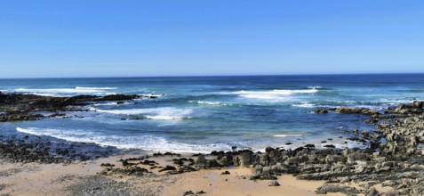 Hiking the fishing trail, Rota Vicentina, Clear blue sky with waves in blue water hitting rocky