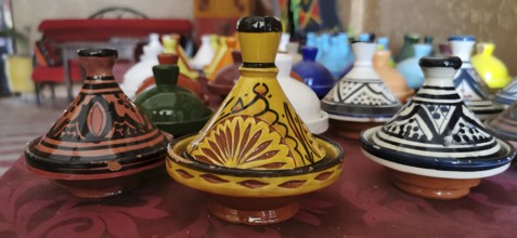 Colourful ceramic tajines in traditional Moroccan designs on a table, Morocco