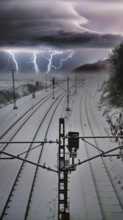 Photo montage of snow-covered train tracks under a dramatic thunderstorm sky with lightning, where