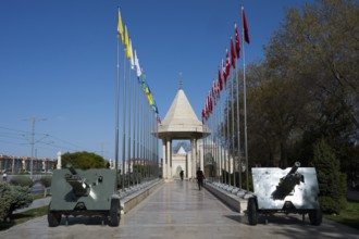 Monument with flag alley flanked by cannons, under a blue sky, Istiklal Harbi Sehitleri Abidesi,