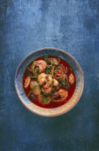 Seafood in tomato sauce with olives, on a dark blue background