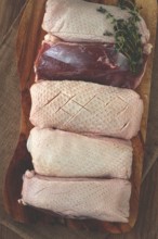Fresh raw duck breast, on a wooden chopping board, top view, no people